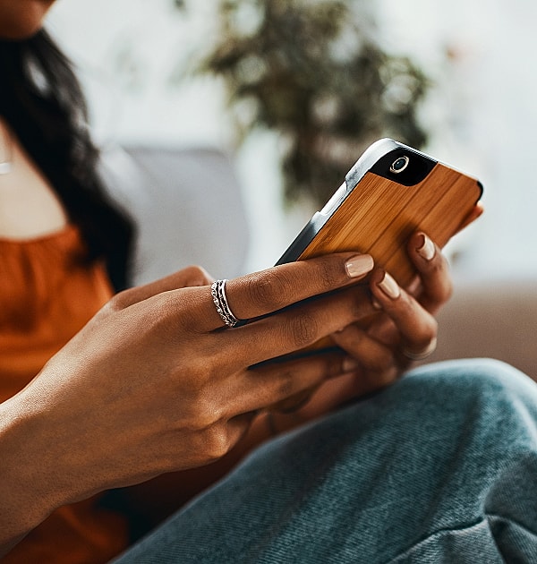 Person using smartphone while relaxing at home.