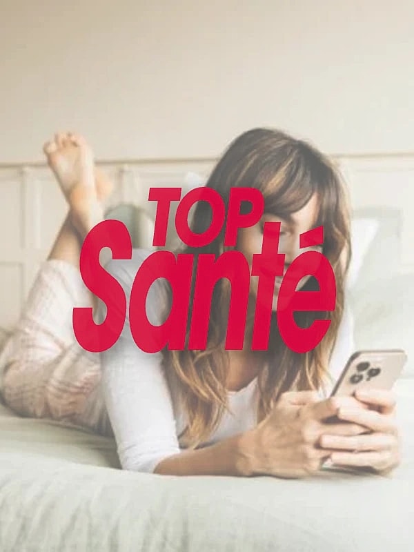 Woman using phone while relaxing on bed.