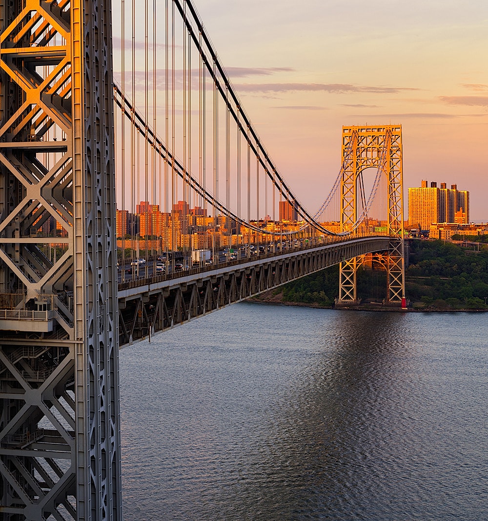 George Washington Bridge at sunset over water.