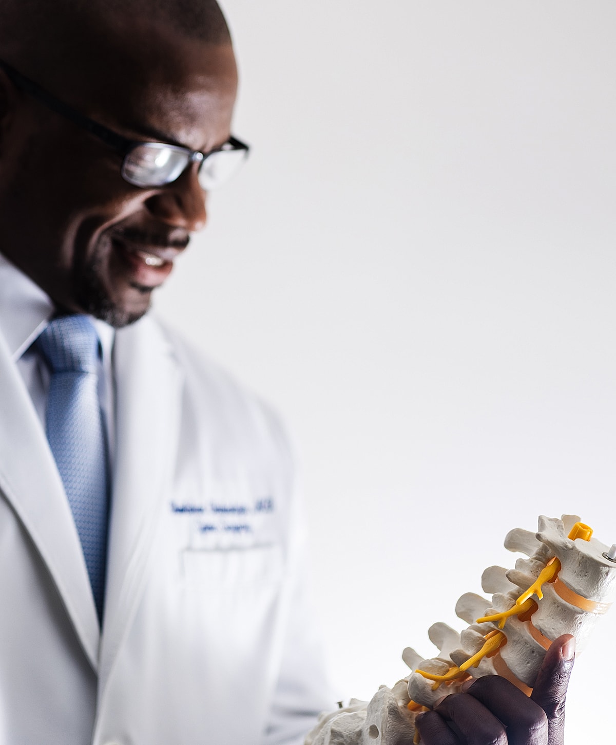 auto accident doctor examining a model of the human spine.