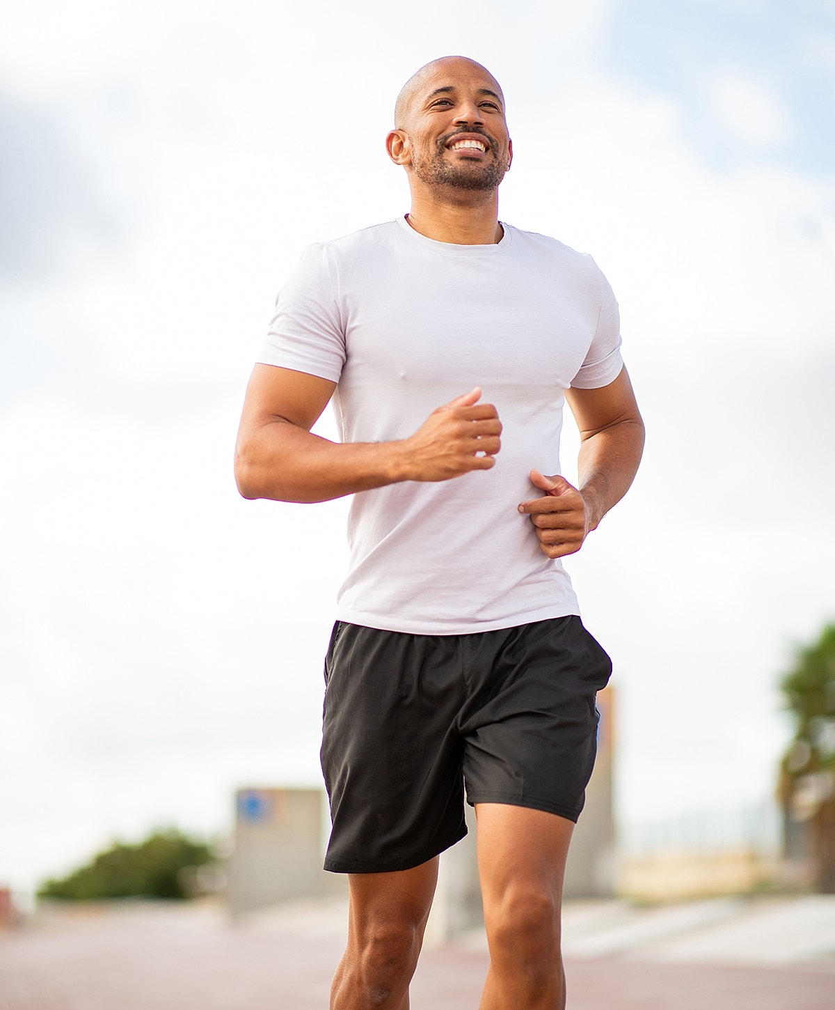 Herniated disc treatment patient model jogging outdoors in athletic clothing, smiling.