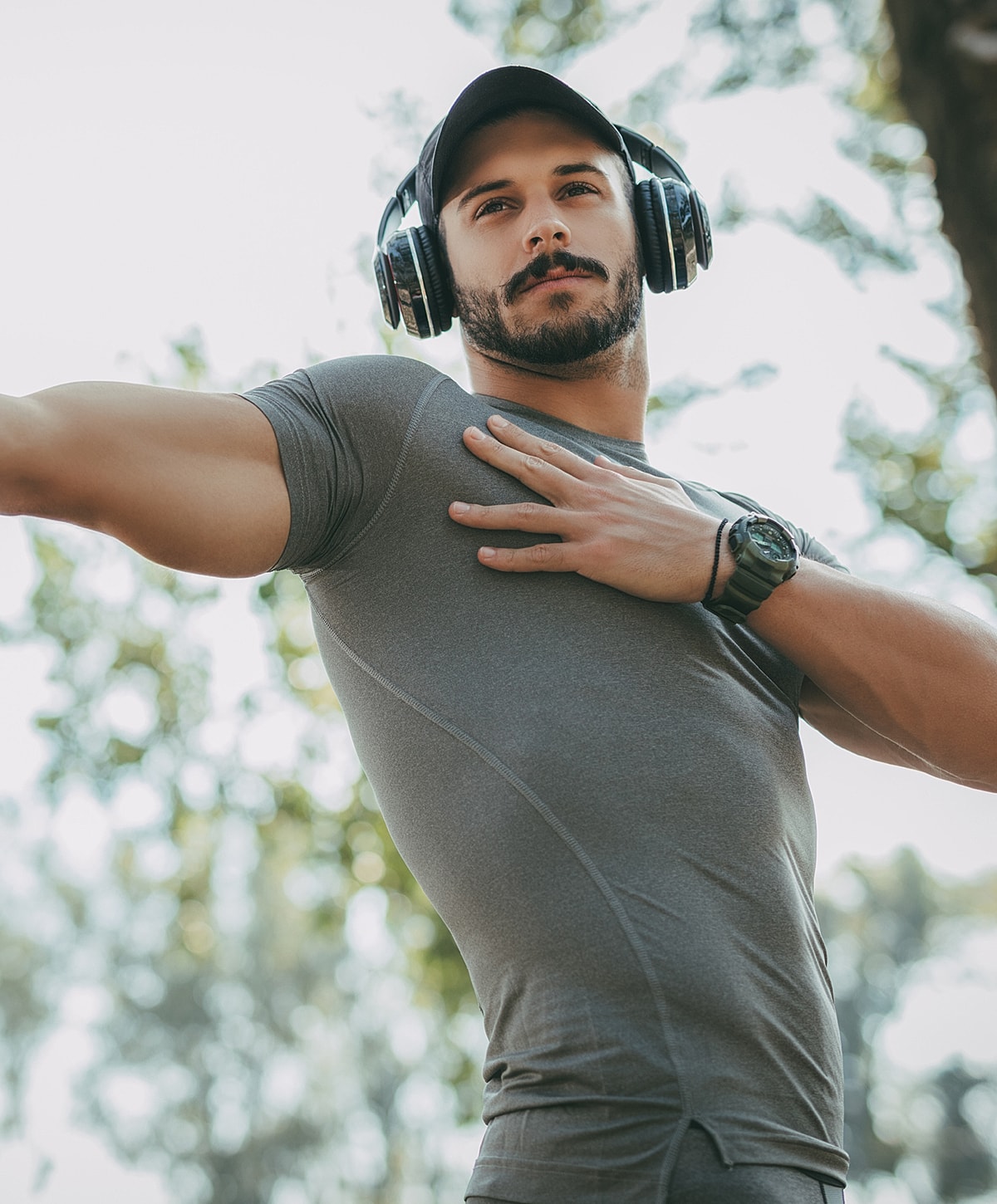 lower back pain treatment patient model in fitness attire wearing headphones outdoors.