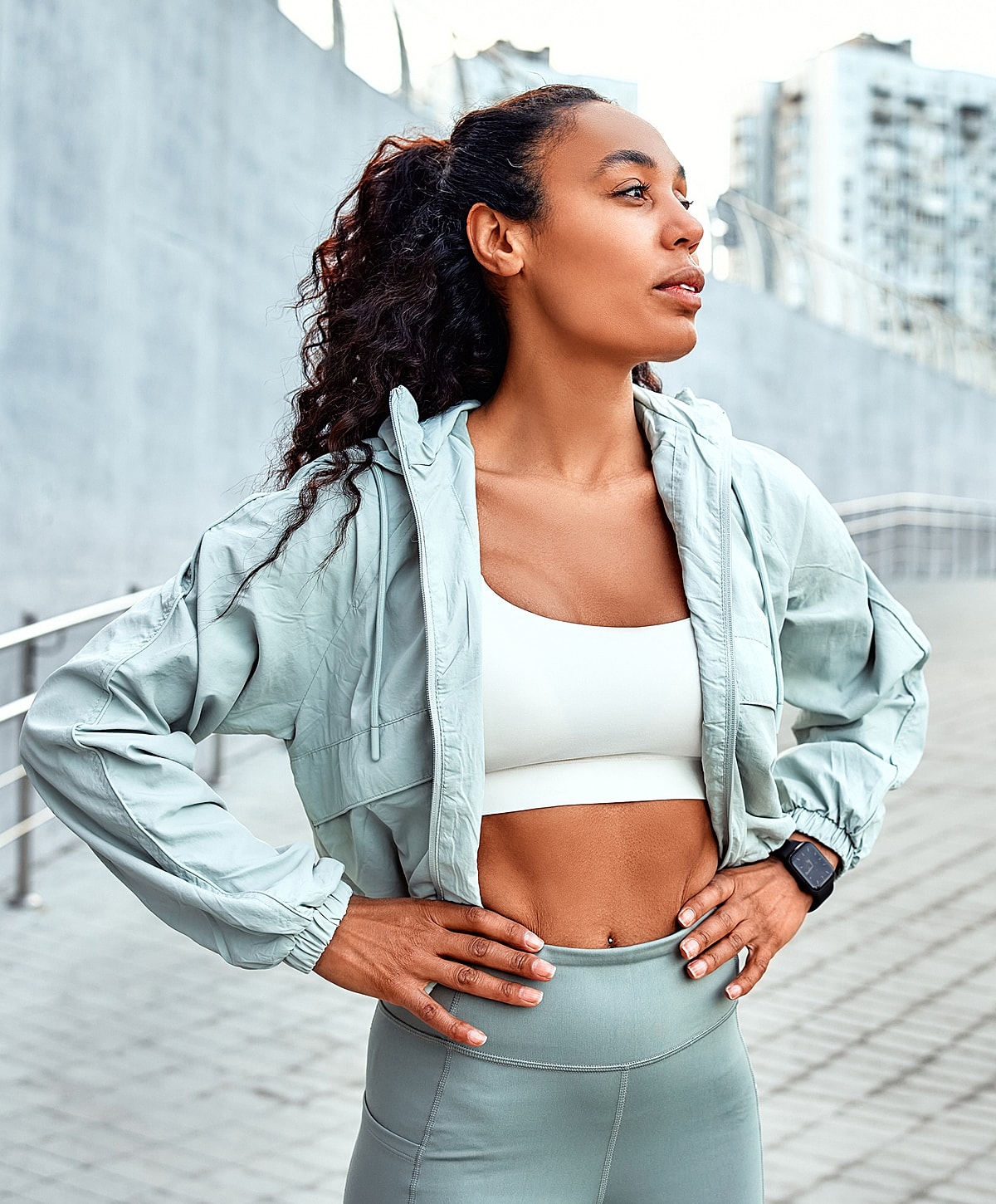 Sporty spondylosis treatment patient model in activewear outdoors looking confident.