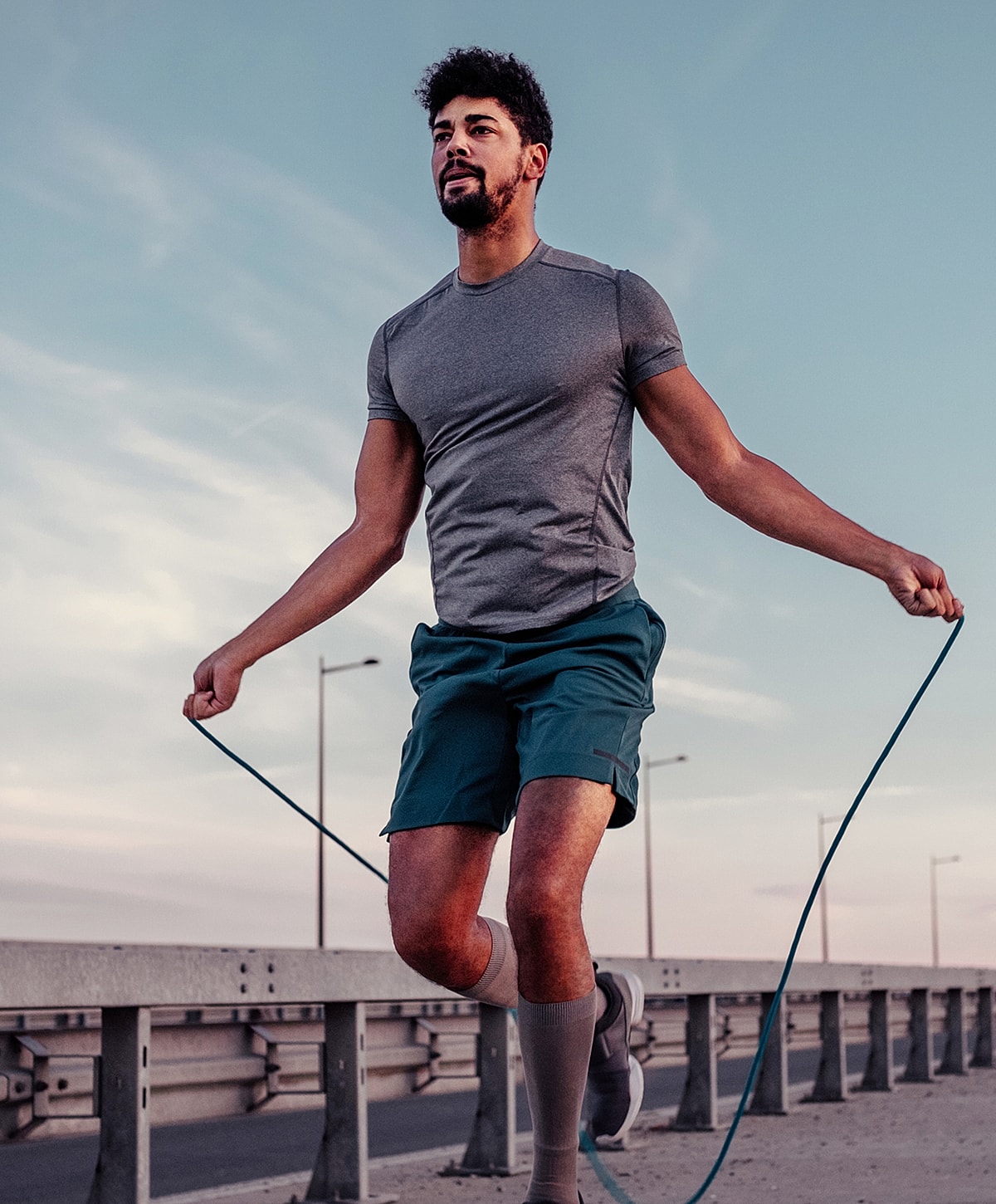 Anterior cervical discectomy patient model skipping rope outdoors in athletic attire.