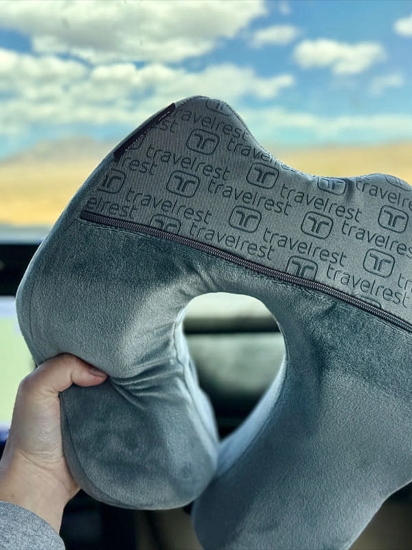 Travel neck pillow held in a car