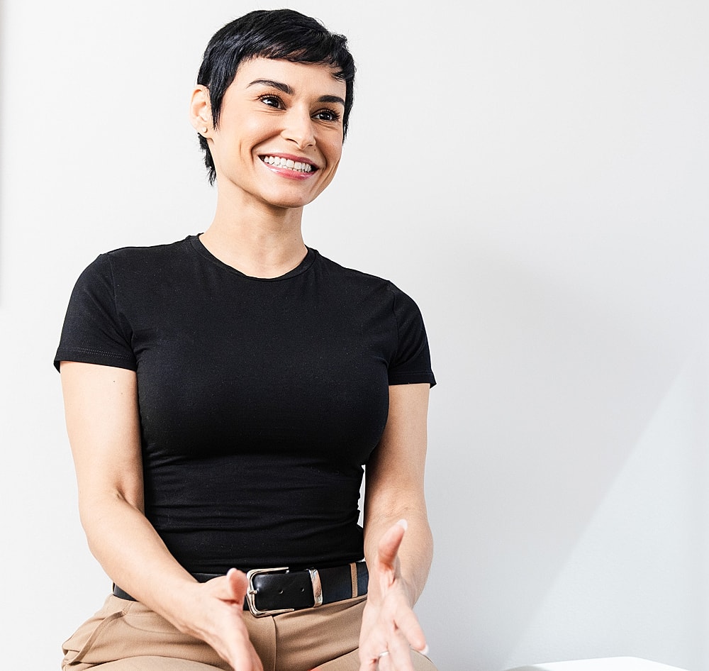 Smiling lumbar microdiscectomy patient model engaging in conversation against white background.