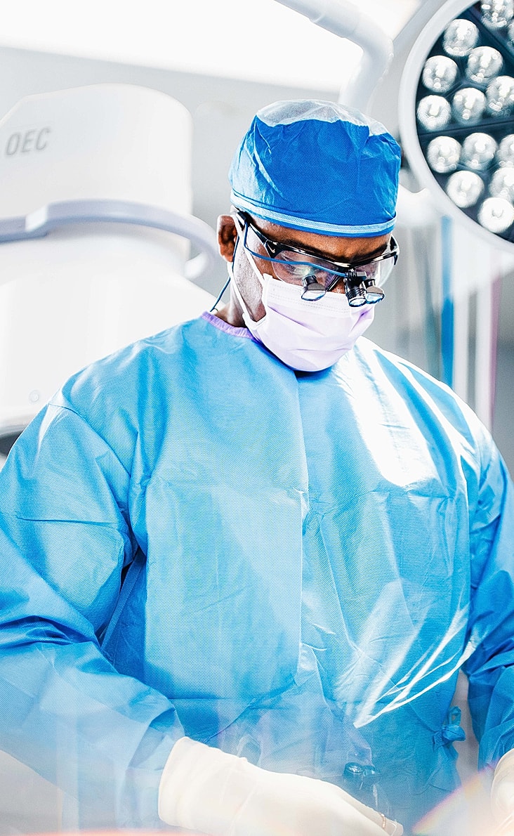 Surgeon preparing for operation in sterile environment.