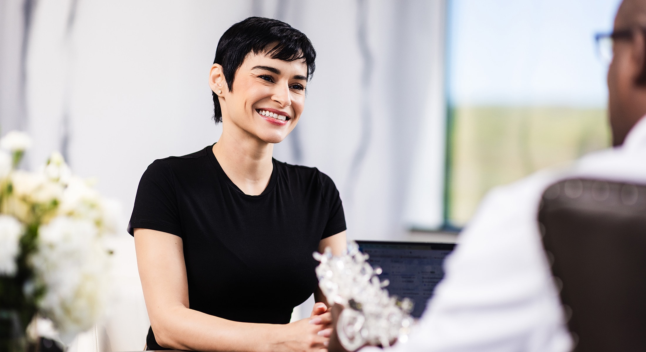 Person smiling in a professional conversation setting.